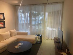 キャバレテにある2 Bedroom Apartmentのソファと大きな窓のあるリビングルーム