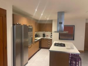 キャバレテにある2 Bedroom Apartmentのステンレス製の冷蔵庫とコンロを備えたキッチン +2枚の写真