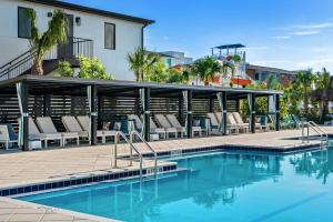 Una piscina con tumbonas al lado de un edificio. en Villatel Orlando Resort, en Orlando