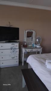 una camera da letto con un letto, un comò e uno specchio di Seas the Breeze Romantic cottage for 2 a Boknes