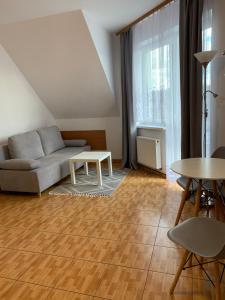 a living room with a couch and a table at Pensjonat Melodia in Pobierowo