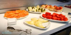 a counter with plates of fruit and bowls of food at Hotel La Alfonsina in Santibáñez de Villacarriedo