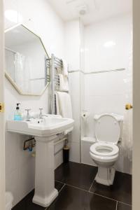 a white bathroom with a sink and a toilet at The Hawk & Buckle Inn in Llannefydd +65 photos