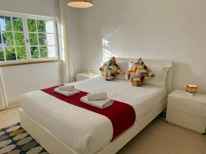 a bedroom with a large white bed with two pillows at Serenity Cascais Villa in Cascais
