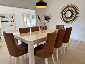 a dining room table with brown chairs and a mirror at Serenity Cascais Villa in Cascais