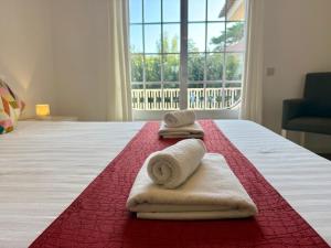 a bedroom with towels on a bed with a window at Serenity Cascais Villa in Cascais