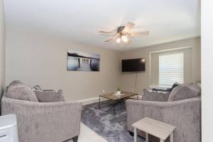 een woonkamer met twee banken en een plafondventilator bij Bay Breeze Escape - 3BR Home with Game Room, Huge Backyard, Patio & Minutes from Boardwalk in Kemah