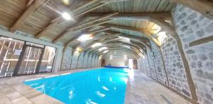 Una gran piscina cubierta con techo de madera. en Chambres d'hôtes - Les Fayards, en Montregard 9 fotos más