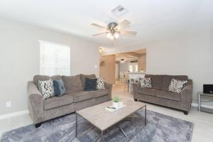 een woonkamer met twee banken en een tafel bij Bay Breeze Escape - 3BR Home with Game Room, Huge Backyard, Patio & Minutes from Boardwalk in Kemah