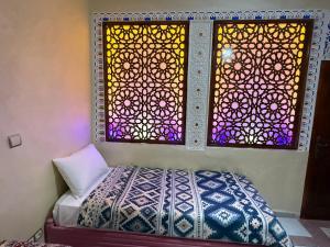 Un dormitorio con una cama y una vidriera. en Anza Lighthouse, en Agadir