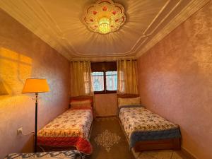 Una pequeña habitación con dos camas y una lámpara. en Anza Lighthouse, en Agadir