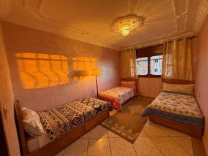 a bedroom with two beds and a lamp in it at Anza Lighthouse in Agadir