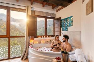 a man and a woman sitting in a bath tub at Carbayu Senda del Oso in Proaza