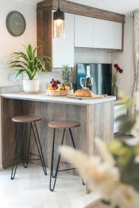 Harbour View Hayling Island في Hayling Island: مطبخ مع كونتر مع الكراسي وطاولة