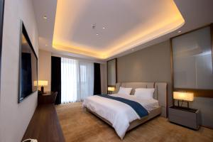 a bedroom with a large bed and a flat screen tv at ESP Hotel in Accra