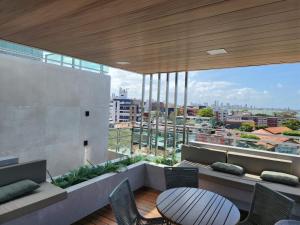 Un balcón con una mesa y sillas en un edificio. en Israel Flat Tambaú - 213, en João Pessoa