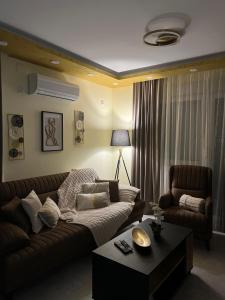 a living room with a couch and a coffee table at Golden Time SM Apartman in Sremska Mitrovica