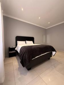 a bedroom with a large bed with a black headboard at 268 Self-catering Apartments in Swakopmund