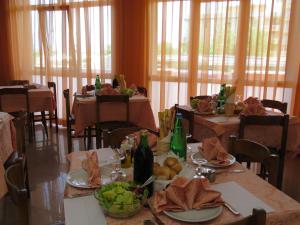 a dining room with tables with bottles and plates of food at Hotel Cliff in Rimini