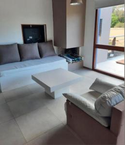 a living room with a couch and a table at Apart Finiterra in Mar de las Pampas