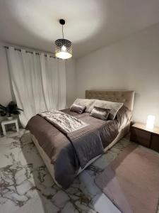 a bedroom with a large bed and a chandelier at Appartement spacieux centre Colmar in Colmar