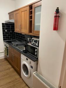 a kitchen with a washing machine and a microwave at Acon Heights in London