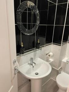 a bathroom with a sink and a mirror and a toilet at Acon Heights in London
