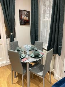 a dining room table with chairs and a table and a window at Acon Heights in London +8 photos