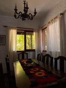 a dining room with a table and a chandelier at Miralejos CARILO PLAYA Y CENTRO in Carilo