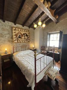 a bedroom with a large bed and a chandelier at Herdade de Açores in Aldeia Rica