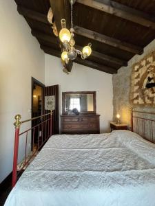 una camera da letto con un letto grande e un lampadario di Herdade de Açores 