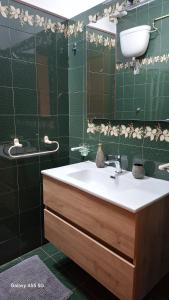 Bed and Breakfast La Reale في ستينتينو: حمام أخضر مع حوض ومرآة +71 صورة