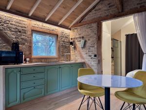 a kitchen with green cabinets and a table at Idyllic cottage with wellness facilities in Alveringem