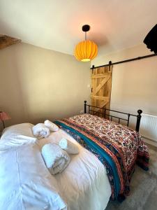 a bedroom with a bed with towels on it at Maggies Cottage in Little Broughton