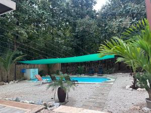 a swimming pool with a blue umbrella over it at Loft en San José de pinilla avellanas guanacaste in San José Pinilla