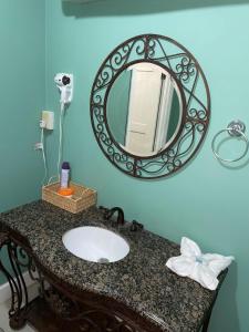 Secret Garden Guest House في Lowlands: حمام مزود بحوض ومِرآة