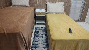 two beds sitting next to each other in a room at Suíte Aconchego na Casa 68 in Belém