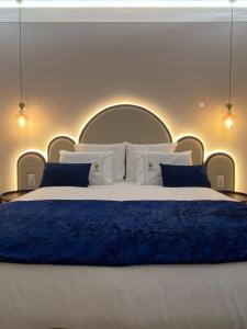 ein Schlafzimmer mit einem großen weißen Bett mit blauen Kissen in der Unterkunft Casa Correio Boutique Hotel in Valença
