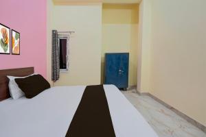 a bedroom with a large bed and a blue door at Hotel O BLISS INN in Chinhat