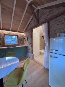 een keuken met een koelkast en een tafel en stoelen bij Idyllic cottage with wellness facilities in Alveringem +12 foto's