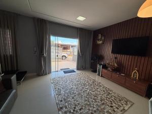 sala de estar con TV y puerta de cristal en Dúplex con impresionantes vistas al mar RAT002, en Perequê