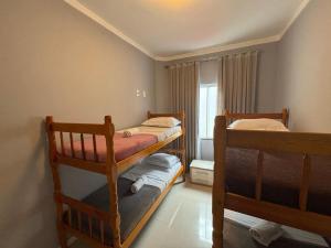 Dos literas en una habitación con ventana. en Dúplex con impresionantes vistas al mar RAT002, en Perequê