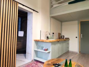 una cucina con un tavolo e alcune bottiglie sul pavimento di Apartament Oaza No 511 Green a Toruń Altre 12 foto