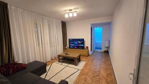 a living room with a couch and a tv at Shakespeare Central Apartment in Craiova