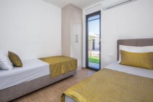 a bedroom with two beds and a sliding glass door at Holiday House Omis - Naklice in Omiš