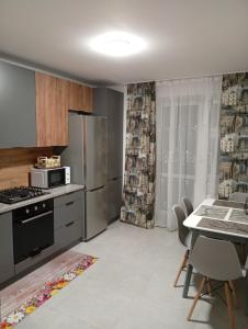 a kitchen with a refrigerator and a table with chairs at Dolce Vita in Ternopil +13 photos