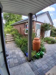 Ferienwohnung MiJo, mit Charme und Ostseenah في Kröpelin: فناء به مزهرية ونباتات أمام منزل +8 صور