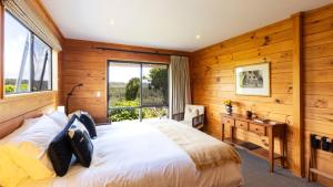 Birds Ferry Lodge Luxury B&B في ويستبورت: غرفة نوم بجدران خشبية وسرير مع نافذة