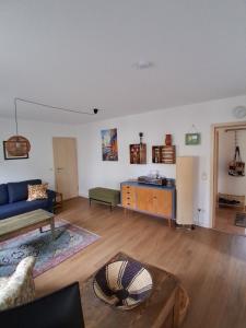 Ferienwohnung MiJo, mit Charme und Ostseenah في Kröpelin: غرفة معيشة مع أريكة زرقاء وطاولة