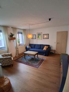 Ferienwohnung MiJo, mit Charme und Ostseenah في Kröpelin: غرفة معيشة مع أريكة زرقاء وطاولة